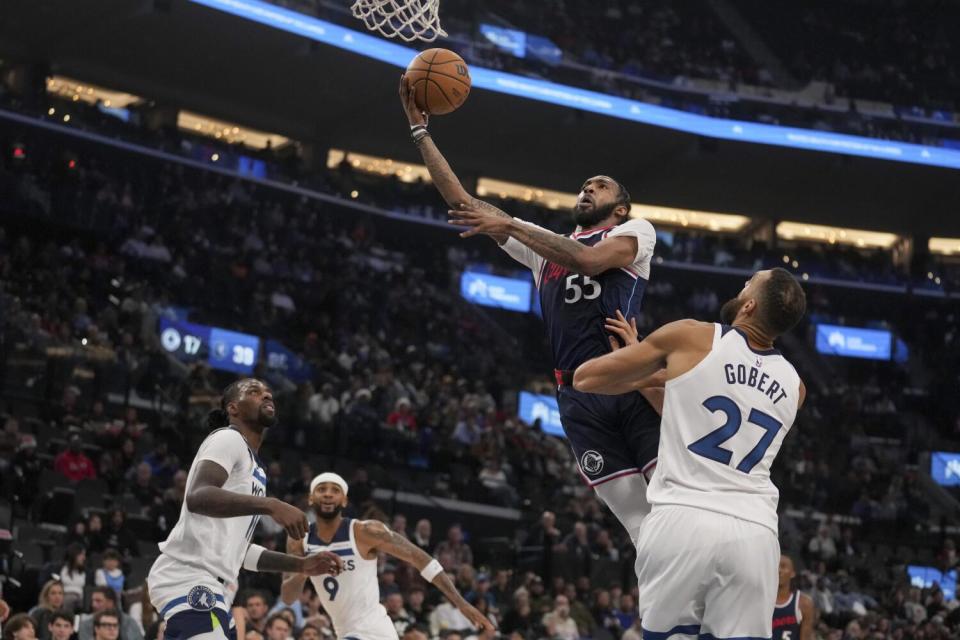 Clippers forward Derrick Jones Jr. drives to the basket in front of Minnesota Timberwolves center Rudy Gobert.