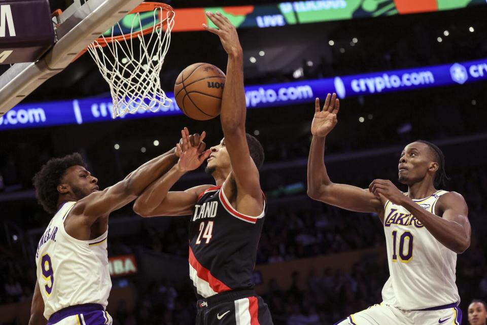 Lakers guard Bronny James, left, blocks shot by Trail Blazers forward Kris Murray, center, during a game Dec. 8.