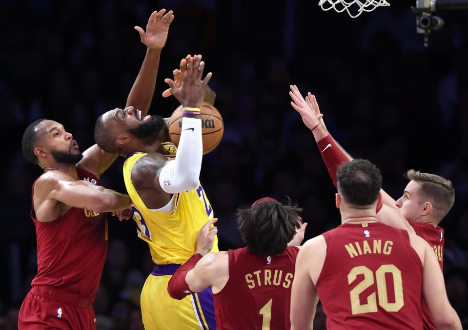 Laker LeBron James tries to get a shot off while surrounded by Cavaliers at Crypto.com Arena Tuesday.