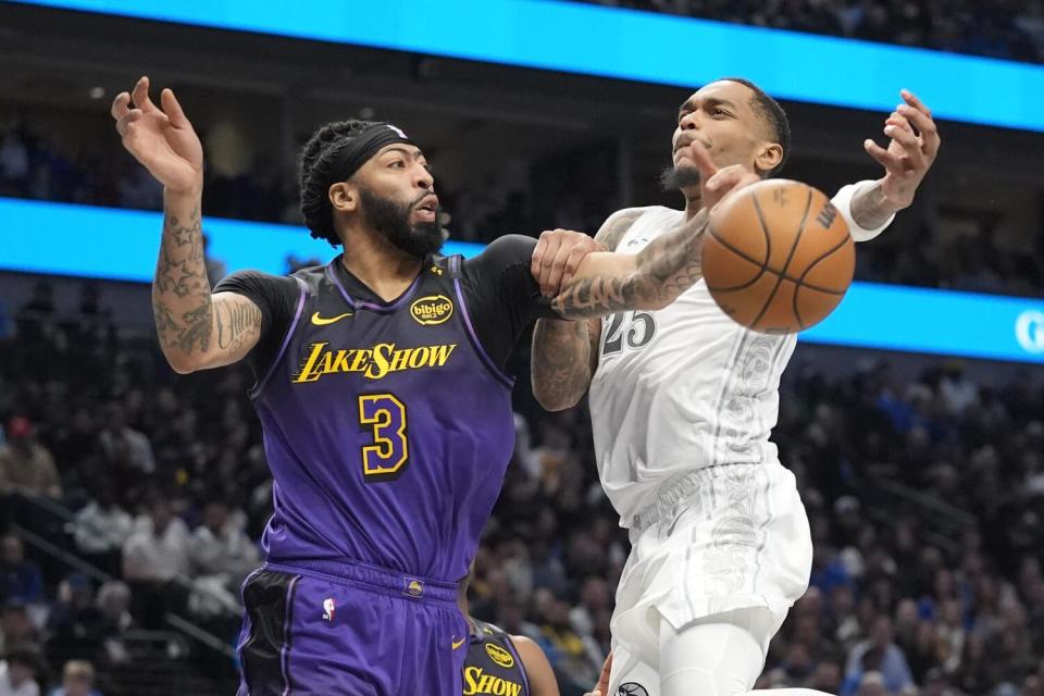 Lakers forward Anthony Davis, left, knocks the ball from Mavericks forward P.J. Washington, right, as he attempts a layup.