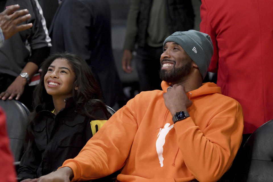 FILE - Former Los Angeles Laker Kobe Bryant and his daughter Gianna Bryant attend an NBA basketball game between the Los Angeles Lakers and Dallas Mavericks Sunday, Dec. 29, 2019, in Los Angeles. (AP Photo/Michael Owen Baker, File)