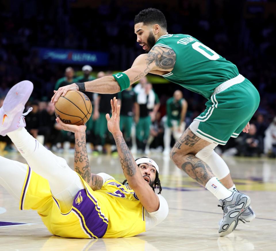 Lakers forward Anthony Davis, bottom, battles for loose ball with Celtics forward Jayson Tatum.