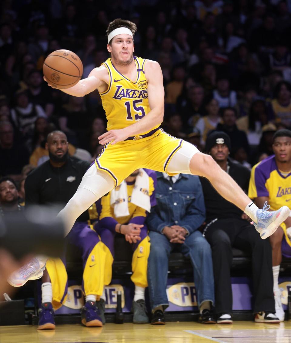 The Lakers' Austin Reaves leaps in the air and passes the ball during a game against the Cavaliers at Crypto.com Arena