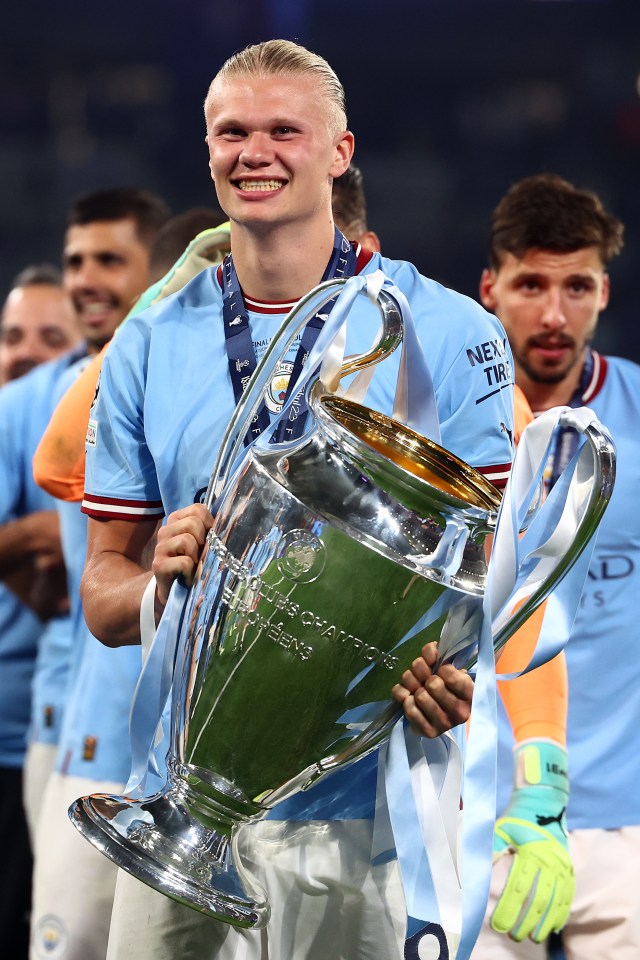 Erling Haaland of Manchester City holding the UEFA Champions League trophy.