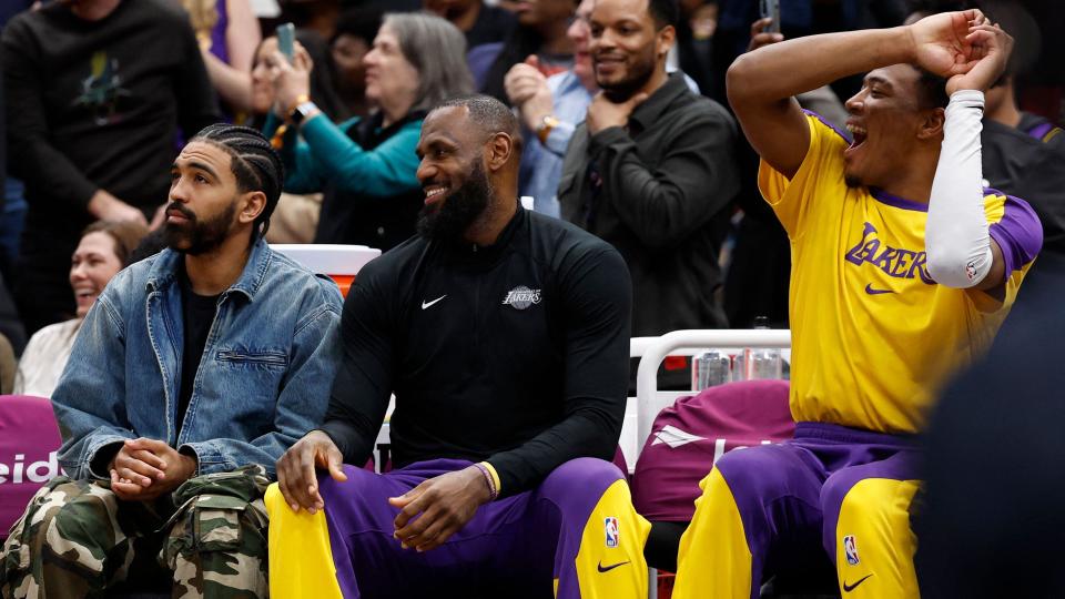 LeBron James smiling on the sidelines during the fourth quarter.