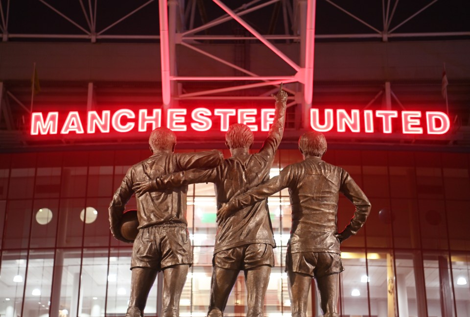 Statue of Sir Bobby Charlton, George Best, and Denis Law outside Old Trafford stadium.