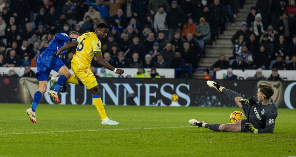 Soccer player in yellow jersey has his shot saved by the goalie.