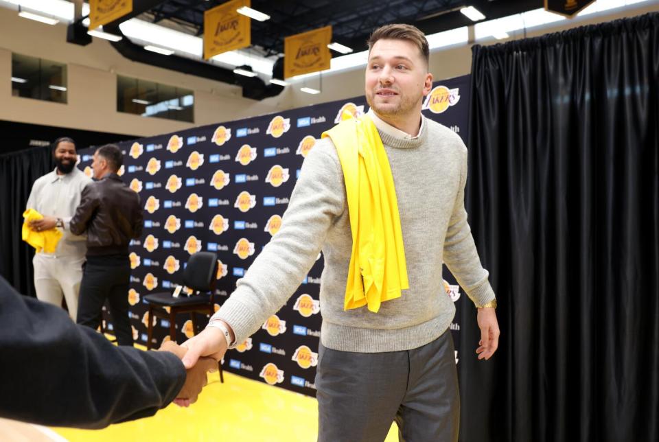 Luka Doncic shakes hands with a person after his introductory news conference at the Lakers' training facility on Tuesday.