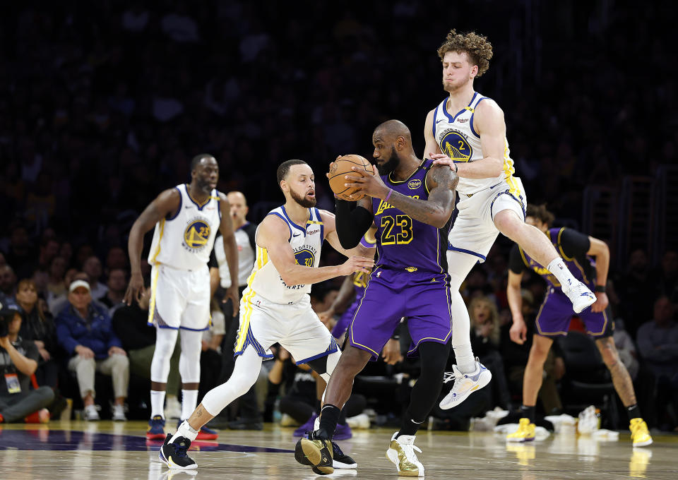 LOS ANGELES, CALIFORNIA - FEBRUARY 06:  LeBron James #23 of the Los Angeles Lakers controls the ball against Stephen Curry #30 and Brandin Podziemski #2 of the Golden State Warriors in the second half at Crypto.com Arena on February 06, 2025 in Los Angeles, California.  NOTE TO USER: User expressly acknowledges and agrees that, by downloading and or using this photograph, User is consenting to the terms and conditions of the Getty Images License Agreement. (Photo by Ronald Martinez/Getty Images)