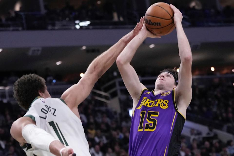 Lakers guard Austin Reaves, right, pulls up for a shot and draws a foul from Bucks center Brook Lopez during the first half.