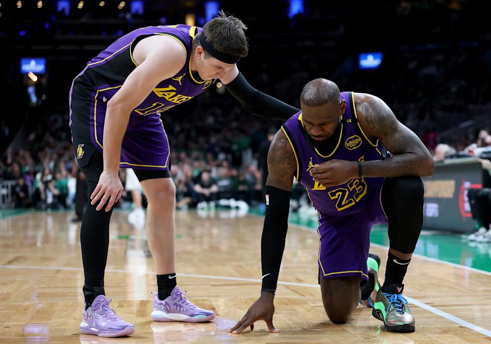 BOSTON, MASSACHUSETTS - MARCH 08: Austin Reaves #15 of the Los Angeles Lakers checks on teammate LeBron James #23 after James collided with Jayson Tatum #0 of the Boston Celtics during the second half at TD Garden on March 08, 2025 in Boston, Massachusetts. The Boston Celtics defeated the Los Angeles Lakers 111-101. NOTE TO USER: User expressly acknowledges and agrees that, by downloading and or using this photograph, User is consenting to the terms and conditions of the Getty Images License Agreement. (Photo by Elsa/Getty Images)