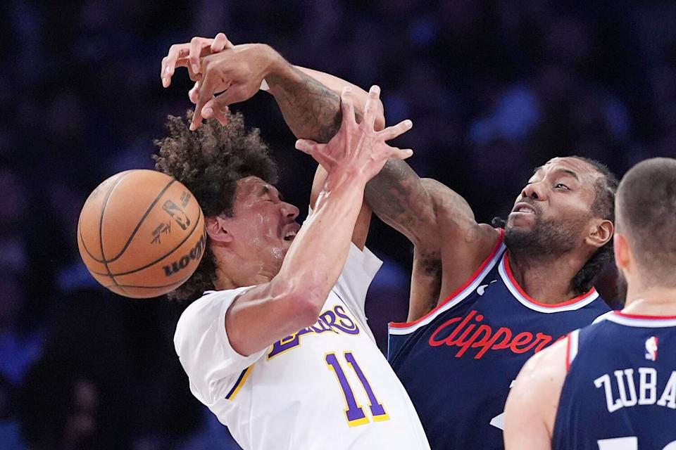 Clippers forward Kawhi Leonard, center, knocks the ball out of the hands of Lakers center Jaxson Hayes.