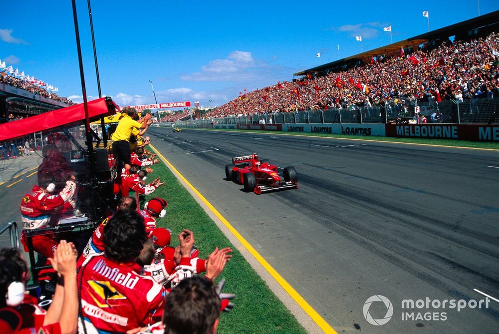 Eddie Irvine, Ferrari F399, celebrates victory as Jordan and Williams mechanics applaud