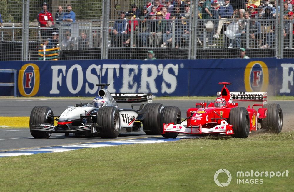 Michael Schumacher, Ferrari F2002, runs wide as he battles with Kimi Raikkonen, Team McLaren Mercedes MP4/17D