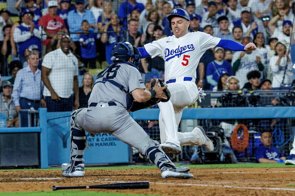 Dodgers baserunner Freddie Freeman, right, beats the tag of New York Yankees catcher Austin Wells to score.