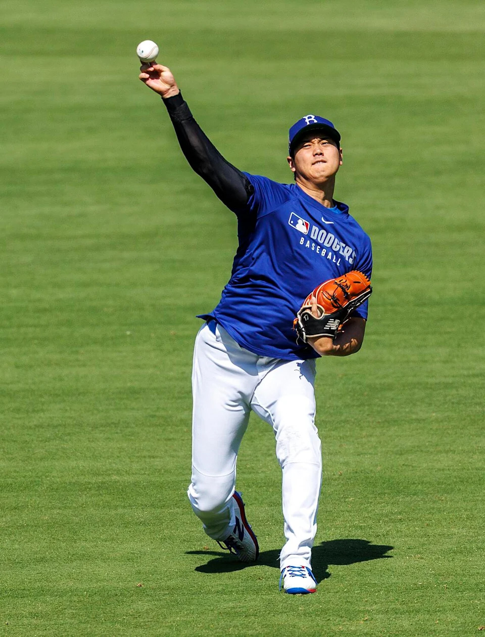 Dodgers Shohei Ohtani (17) throws warm-up pitches in the outfield before the game against the New York Mets.