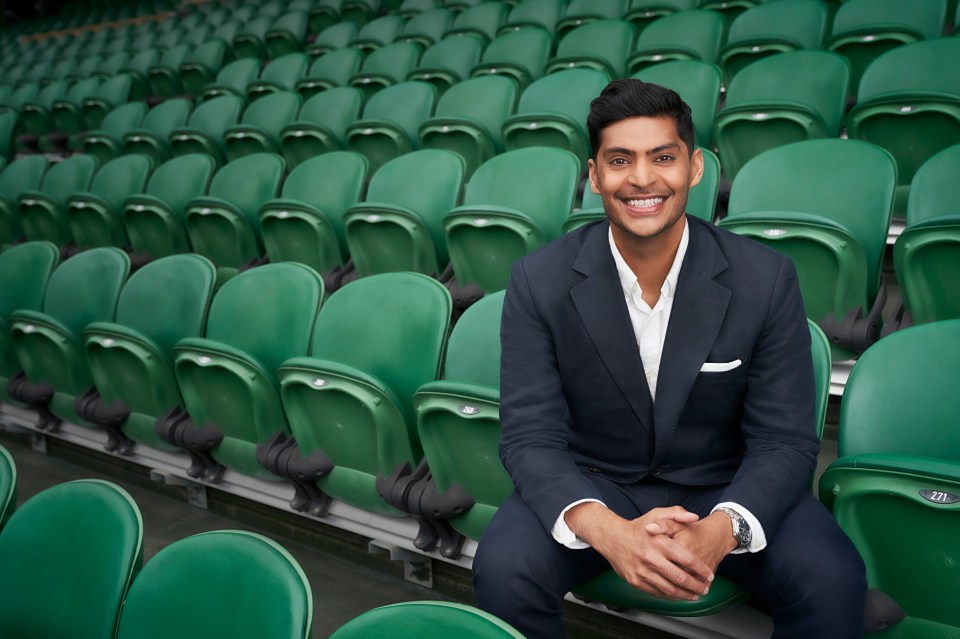 Man in suit sitting in stadium seats.