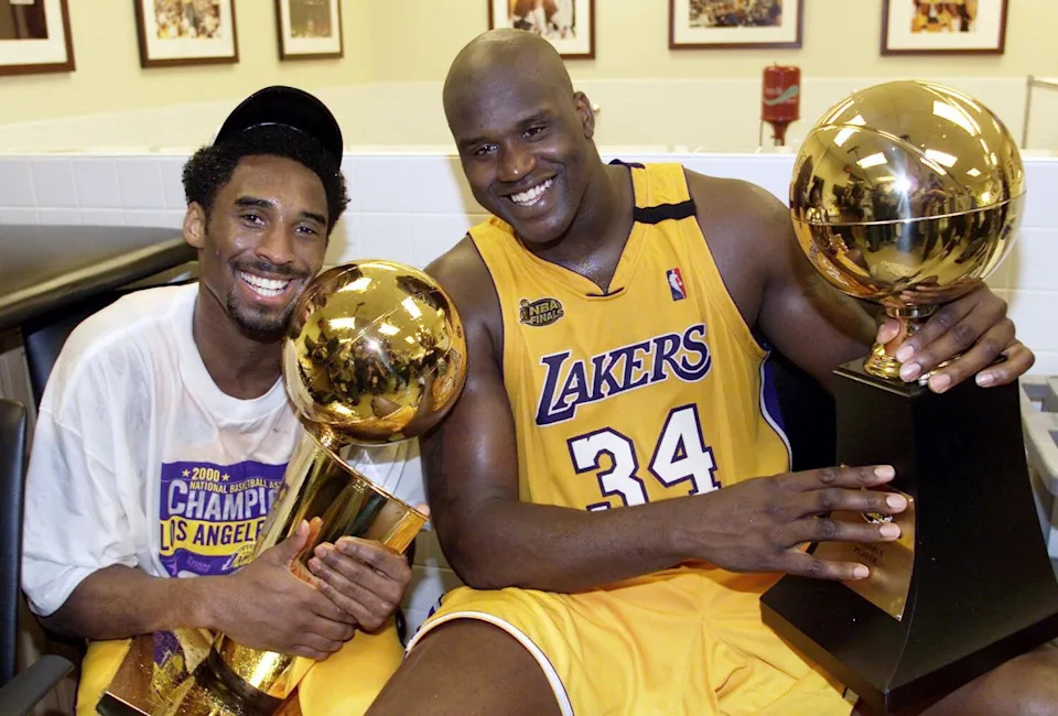 Kobe Bryant, left, holds the Larry O'Brian Trophy as Shaquille O'Neal holds the NBA Finals MVP trophy in 2000.