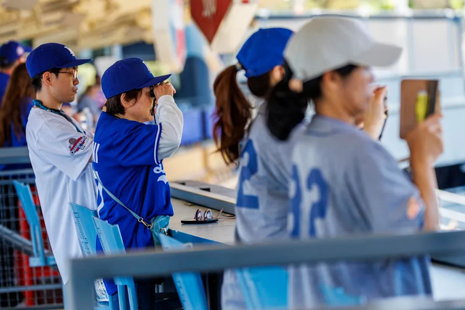 Dodgers fans watch as Los Angeles Dodgers Shohei Ohtani (17) throws warm-up pitches in the outfield.