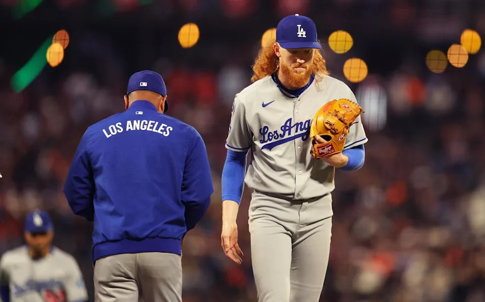 Dustin May exits during the fifth inning of a game.