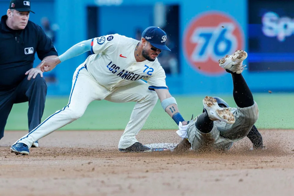 Dodgers second base Miguel Rojas tags out San Diego Padres shortstop Xander Bogaerts.