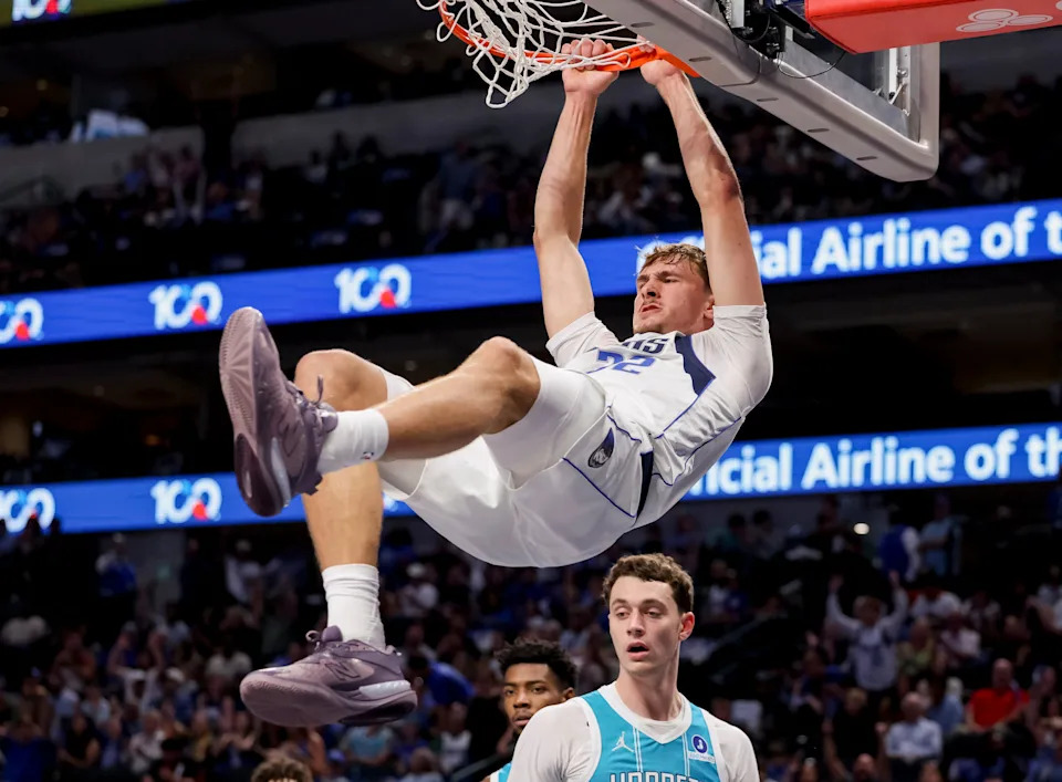 Dallas Mavericks forward Cooper Flagg, center, dunks during the first half of an NBA basketball preseason game against the Charlotte Hornets in Dallas, Saturday, Oct. 11, 2025. (AP Photo/Gareth Patterson)