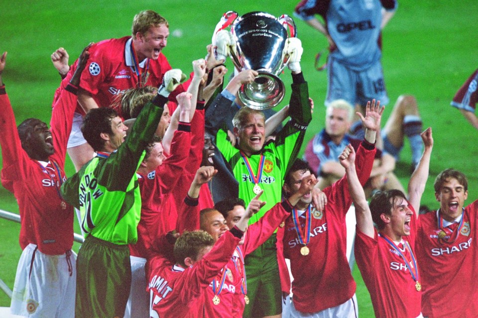 Manchester United players celebrating with the UEFA Champions League trophy.