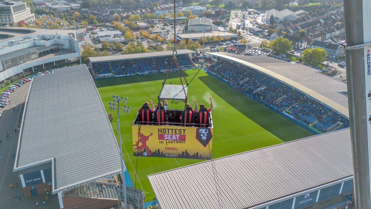 Four lucky football fans were hoisted 50 metres to enjoy the football drink in hand