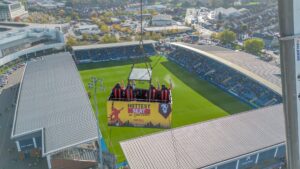 Four lucky football fans were hoisted 50 metres to enjoy the football drink in hand