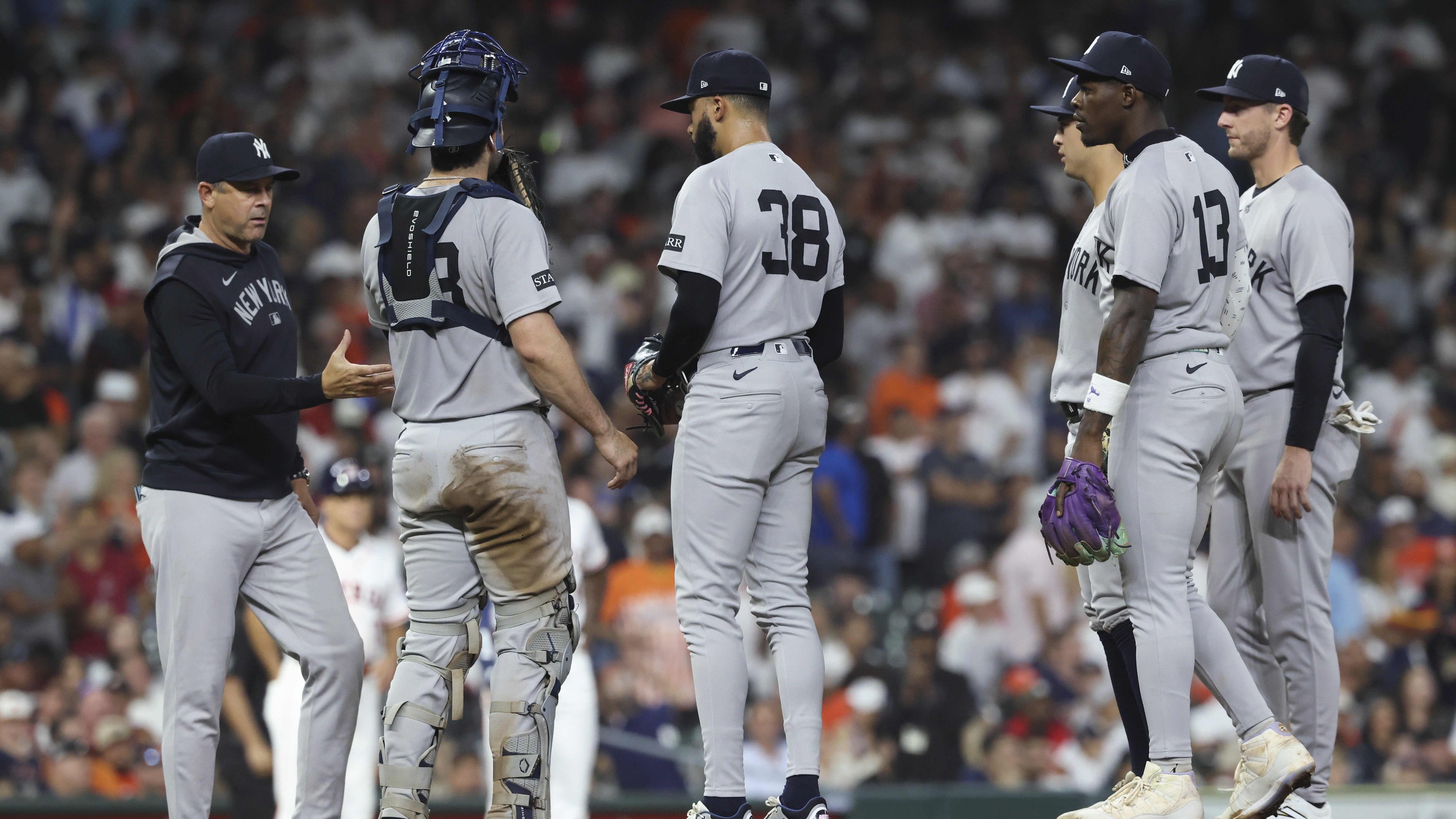 Sep 3, 2025; Houston, Texas, USA; New York Yankees relief pitcher Devin Williams (38) gives the ball to manager Aaron Boone during a pitching change in the eighth inning against the Houston Astros at Daikin Park.