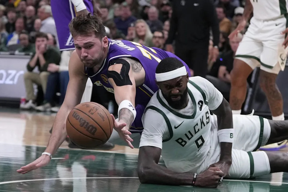 The Bucks' Bobby Portis and the Lakers' Luka Doncic battle for a loose ball on Saturday in Milwaukee.