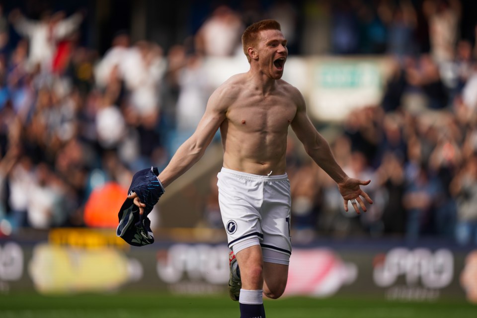 Millwall player Duncan Watmore, shirtless, celebrates his goal to make it 3-1, with his mouth open and arms wide.