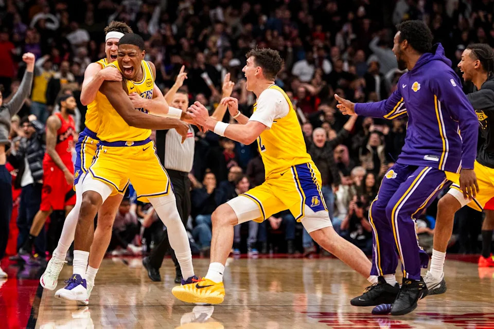 Lakers forward Rui Hachimura celebrates with Austin Reaves, top left, and Jake LaRavia.