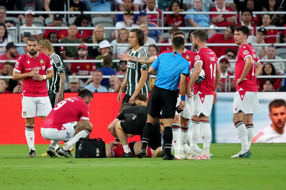 Manchester United vs Wrexham AFC preseason friendly, showing a Wrexham player receiving medical attention on the field.