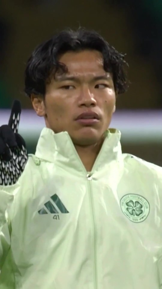A male soccer player in a light green jacket with a Celtic FC logo.