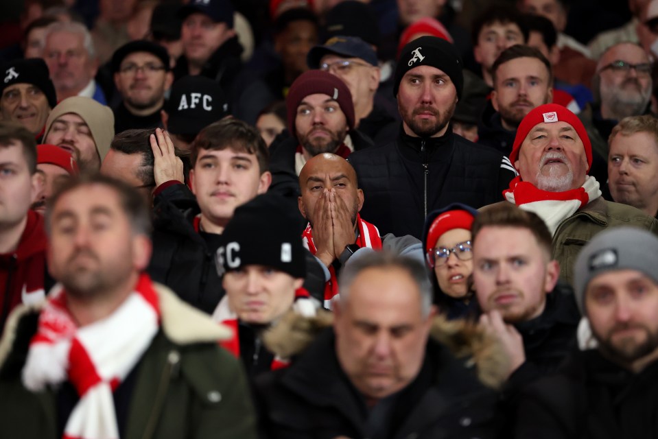 Fans of Arsenal reacting during a football match.