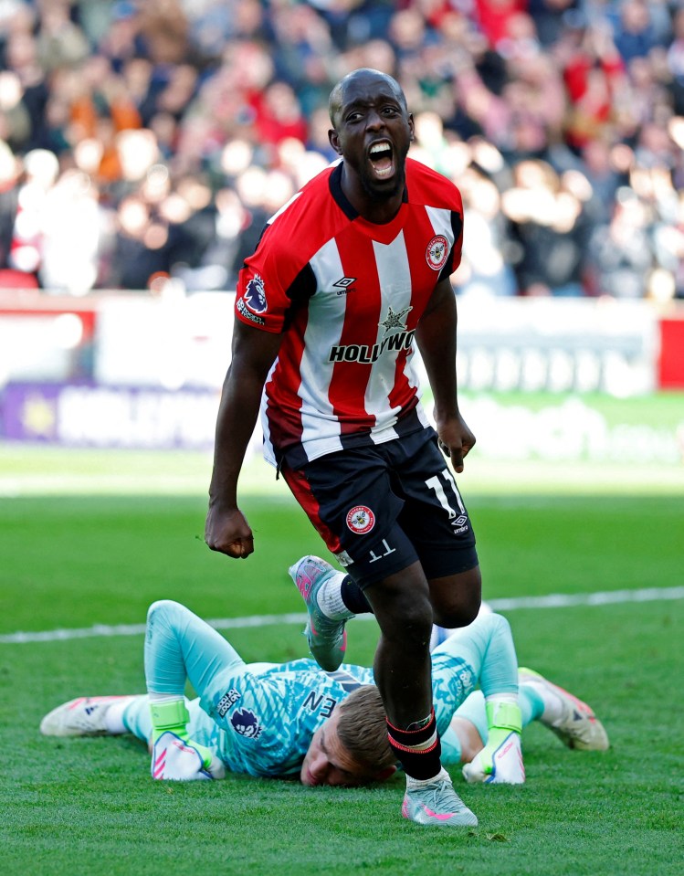 Brentford's Yoane Wissa celebrates scoring a goal over a fallen Brighton & Hove Albion goalkeeper.