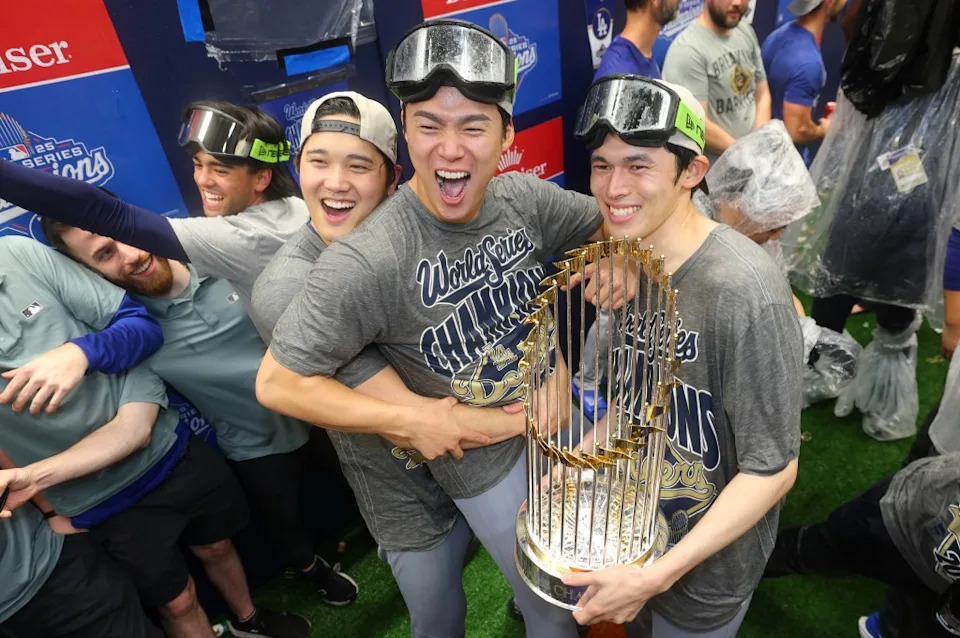 Shohei Ohtani #17, Yoshinobu Yamamoto #18, and Roki Sasaki #11 of the Los Angeles Dodgers celebrate in the locker room after defeating the Toronto Blue Jays 5-4 in game seven to win the 2025 World Series. Getty Images