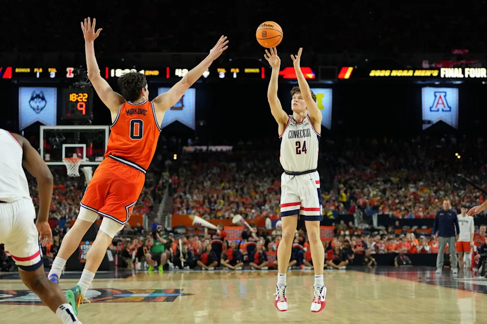 UConn Huskies guard Braylon Mullins (24) shoots the ball against Illinois Fighting Illini forward David Mirkovic (0) during the second half of a semifinal of the Final Four of the men's 2026 NCAA Tournament at Lucas Oil Stadium.