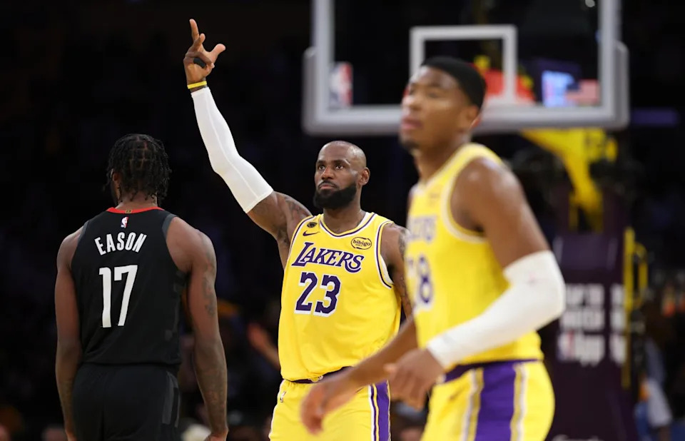 LeBron James raises his right hand signaling a three-point basket over Rockets forward Tari Eason.