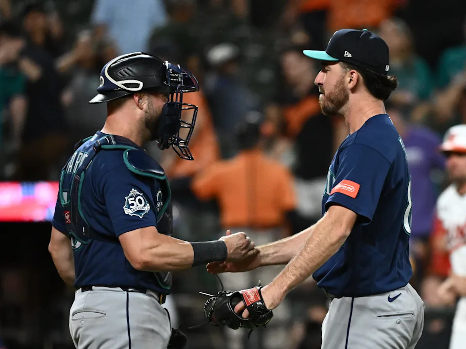 Nick Davila celebrates his first career save with Seattle Mariners catcher Mitch Garver at Oriole Park at Camden Yards.