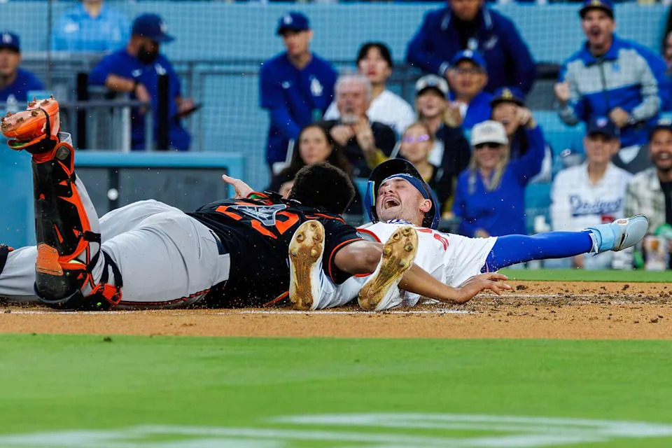 Alex Freeland signals safe after sliding past Baltimore catcher Samuel Basallo to score on a double by Andy Pages.