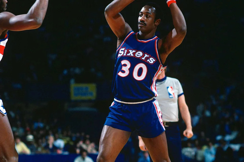 BALTIMORE, MD – CIRCA 1978: George McGinnis #30 of the Philadelphia 76ers looking to pass the ball against the Washington Bullets during an NBA basketball game circa 1978 at the Baltimore Civic Center in Baltimore, Maryland. McGinnis played for the 76ers from 1975-78. (Photo by Focus on Sport/Getty Images) | Getty Images